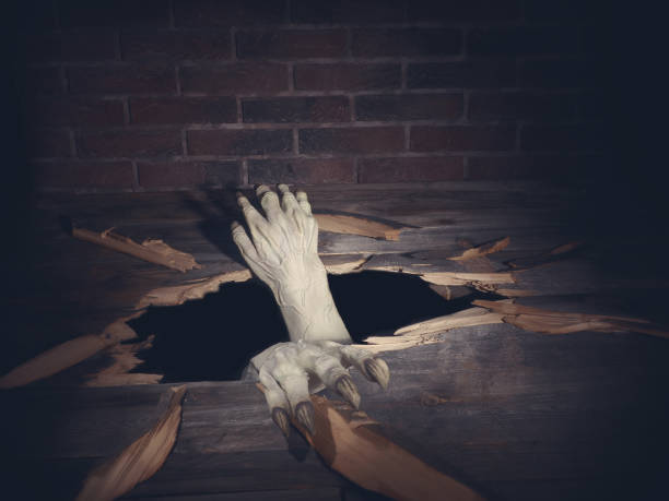 istock Zombie hand through hole cracked in rustic wood.Halloween theme 1038734726