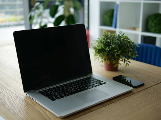 istock Laptop and phone on a wooden old table 1038734944
