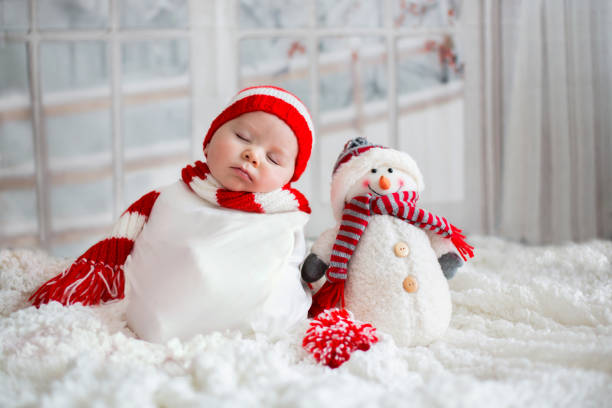 Christmas portrait of cute little newborn baby boy, wearing santa hat Christmas portrait of cute little newborn baby boy, wearing santa hat and  little cute snowman toy, studio shot, winter time teddy bear photos stock pictures, royalty-free photos & images