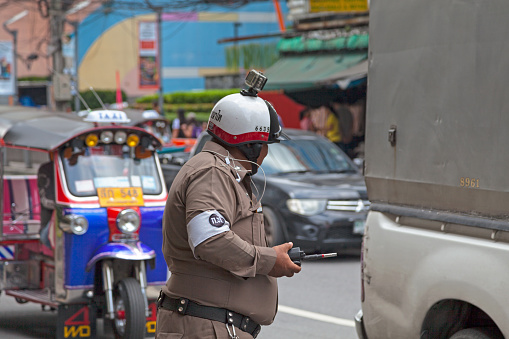 Bangkok, Thailand - September 17 2018: Police officer doing the traffic with a camera atop of his helmet to avoid comflict with drivers.