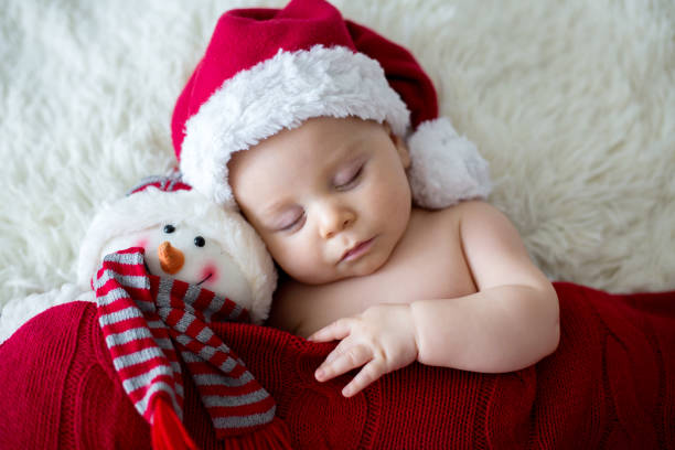 bambino appena nato addormentato, che indossa il cappello di babbo natale - baby santa claus christmas sleeping foto e immagini stock