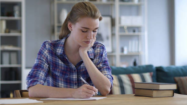 istock Tired Young Woman Writing on Paper and Sleeping 1038744172