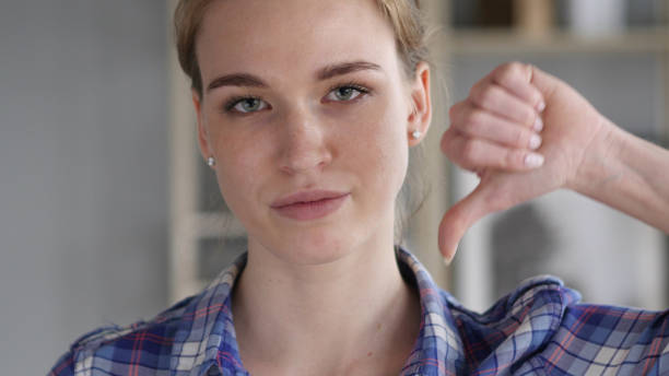 istock Thumbs Down by Young Woman at Work,  Looking at Camera 1038745430