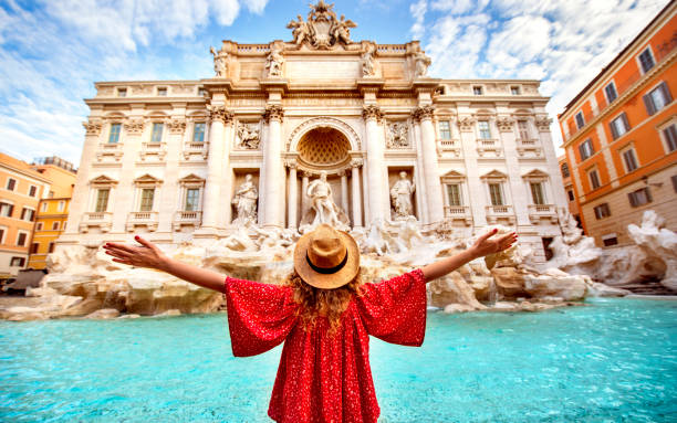 молодая женщина руки подняты на фонтан треви рим - rome стоковые фото и изображения