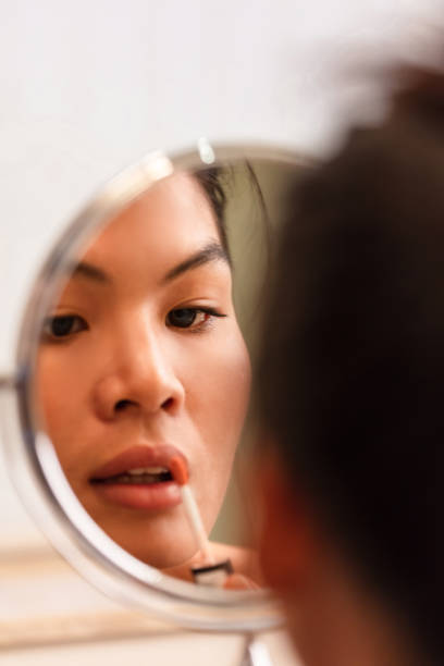 istock Asian woman applying make-up 1038785144