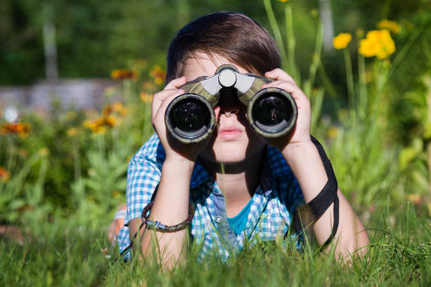 istock Boy young researcher exploring with binoculars environment in green garden 1038787706