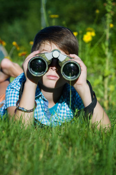 istock Boy young researcher exploring with binoculars environment in green garden 1038787724