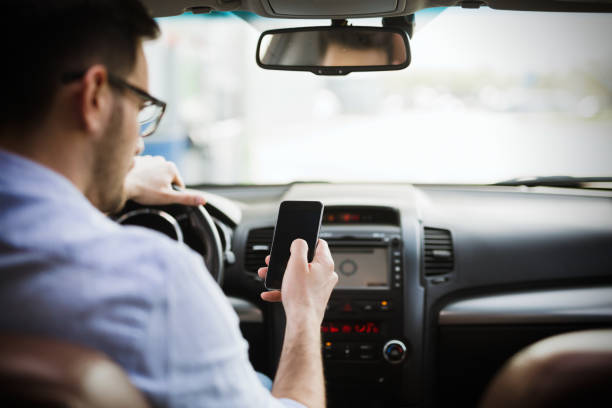 istock Businessman ignoring safety and texting onmobile phone while driving 1038806812