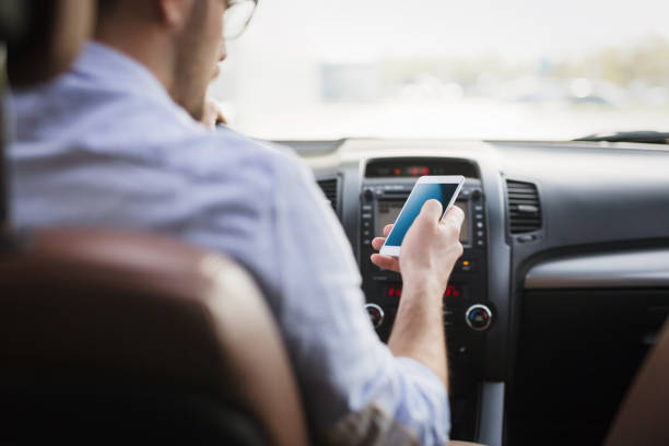 istock Businessman ignoring safety and texting onmobile phone while driving 1038806920