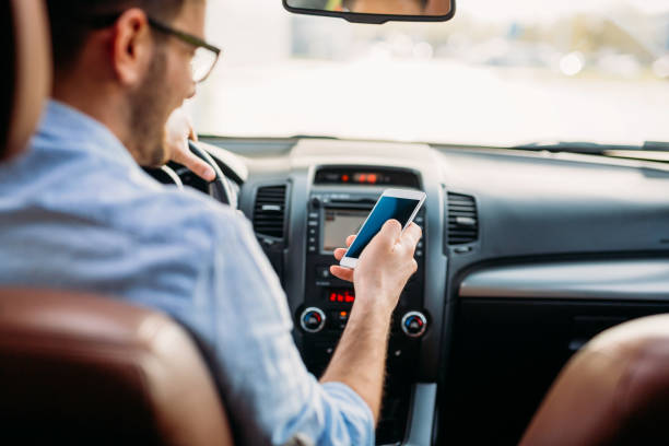 istock Businessman ignoring safety and texting onmobile phone while driving 1038806964