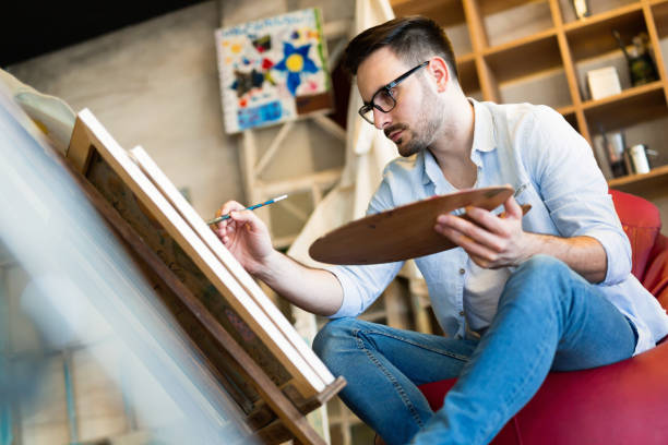 Young man painting on canvas