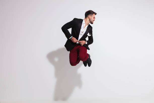 istock funny gentleman jumping while buttoning suit and looking to side 1038809444