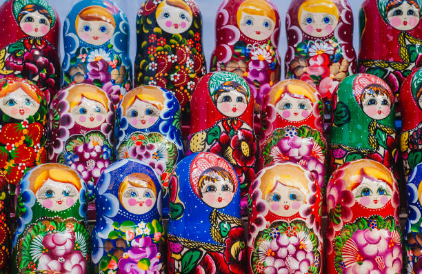 красочные русские вложенные куклы на рынке. - russian nesting doll фотографии стоковые фото и изображения