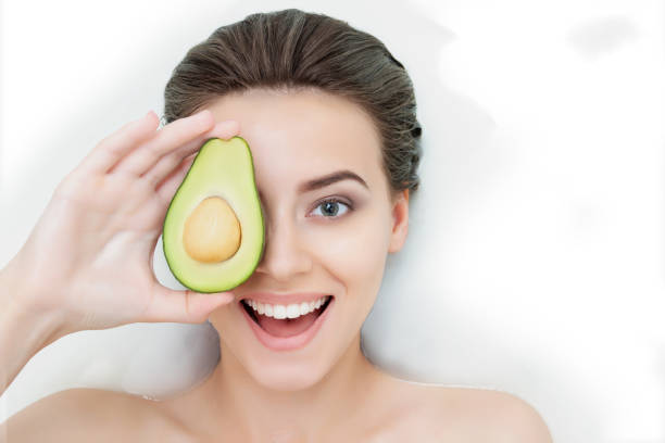 retrato de mujer joven relajándose en la bañera de hidromasaje blanco - avocado cross section vegetable seed fotografías e imágenes de stock