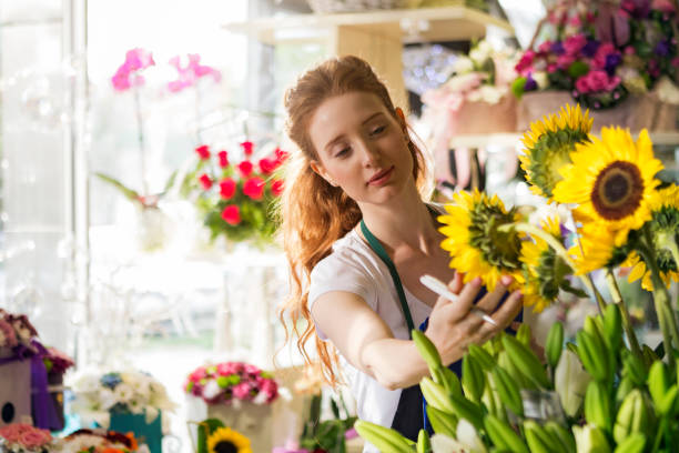 젊은 여자에 의해 지도 하는 꽃집 - florist 뉴스 사진 이미지