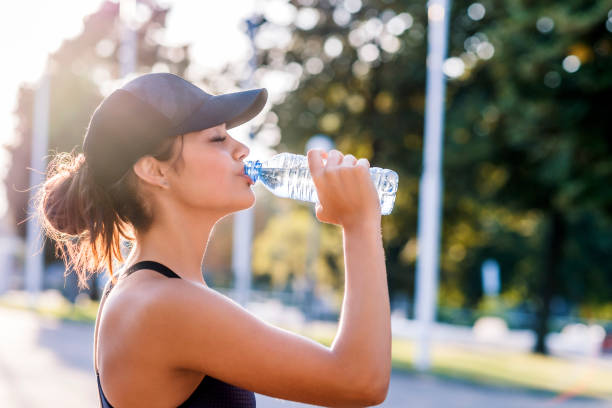 photo of sporty young woman drinking water - bebida imagens e fotografias de stock
