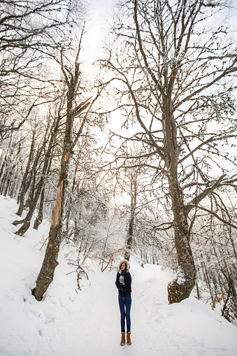 Young woman hiking in the winter on the snowy mountain