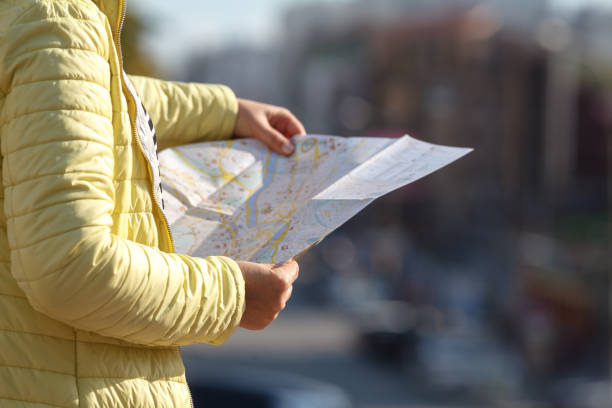 istock tourist looking at the paper map instead phone. Positive emotion. 1038852894
