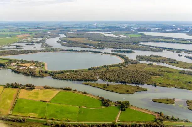 Aerial photo of artificially constructed water basins in the Dutch National Park De Biesbosch. In the foreground the basin Petrusplaat, completed in 1974. In the reservoirs water from the river Maas is stored and purified later for the benefit of the drinking water supply in a large part of the Netherlands. The Amer river winds through the landscape in the background