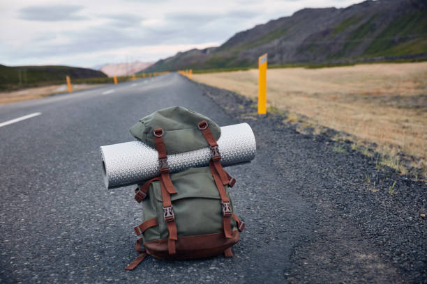 Mountain landscape. Big backpack standing on roadside