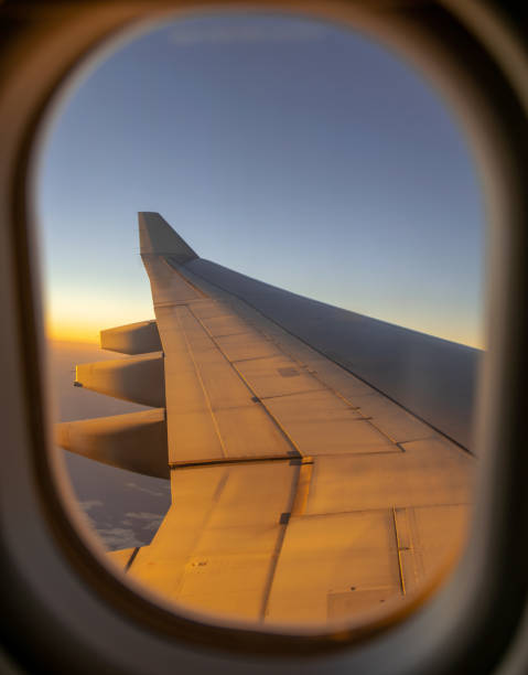istock Stunning evening view through an airplane window onto the left wing during a flight across Australia. Shortly before sunset, the wing is illuminated by the sun. Clear blue sky, selective focus on wing 1038863124