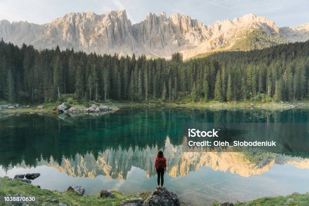 Donna In Piedi E Guardando Il Lago Di Carezza Nelle Dolomiti - Fotografie stock e altre immagini di Natura
