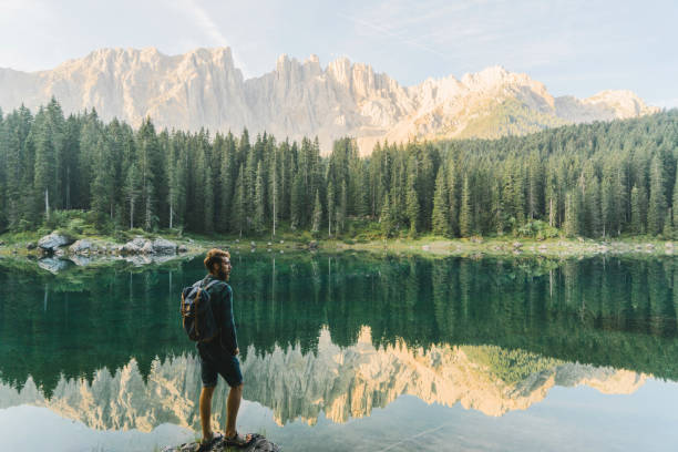 istock Man standing and looking at  Lago di Carezza in Dolomites 1038870736