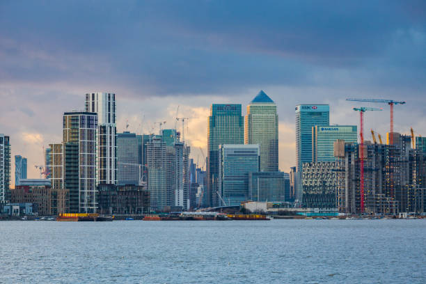 The skyscrapers of Canary Wharf and North Greenwich seen from the distance with Thames in foreground, January 2018, London