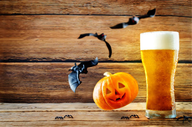 カボチャとコウモリが飛んで冷や光のビールのグラス - glass autumn halloween food ストックフォトと画像