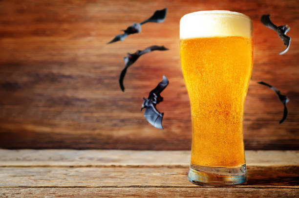 コウモリの飛行を冷や光のビールのグラス - glass autumn halloween food ストックフォトと画像