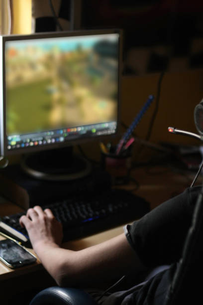 istock Teenage boy playing games on his computer at home 1038878974