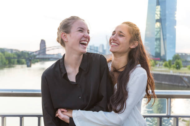 istock Girlfriends Embracing and Laughing Wildly on City Bridge Over River 1038879520