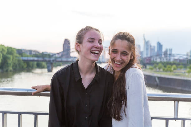 istock Girlfriends Laughing on City Bridge Over River 1038879538