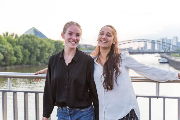istock Girlfriends Smiling on City Bridge Over River 1038879540