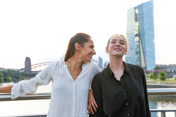 istock Girlfriends Smiling on City Bridge Over River 1038879836
