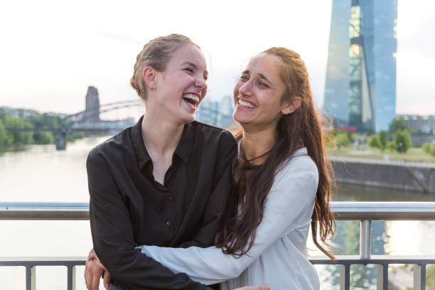 istock Girlfriends Embracing and Laughing Wildly on City Bridge Over River 2 1038879928