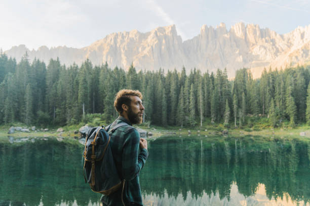 istock Man standing and looking at  Lago di Carezza in Dolomites 1038881184