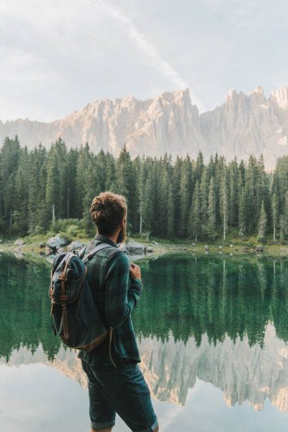 istock Man standing and looking at  Lago di Carezza in Dolomites 1038881192