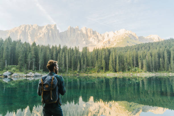 mann stehend und mit blick auf den lago di carezza in dolomiten - austria european alps landscape lake stock-fotos und bilder