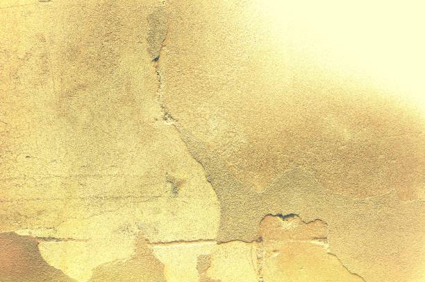 istock Damaged and peeled cement wall surface. Yellow tones. Useful for texture or background. 1038887410