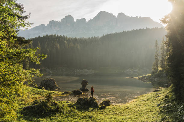 Woman standing and looking at  Lago di Carezza in Dolomites