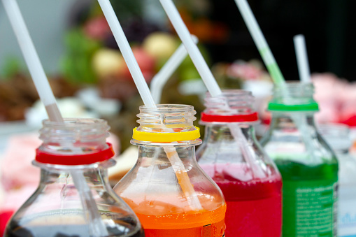 Colorful of carbonated soft drink pop soda bottles with plastic straw. Plastic bottles of assorted carbonated in variety of colors.
