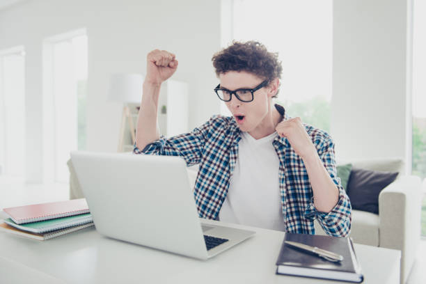 istock Handsome curly-haired happy young guy student at home, wearing c 1038898368