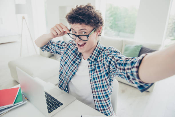 Handsome curly-haired excited young guy student at home, wearing