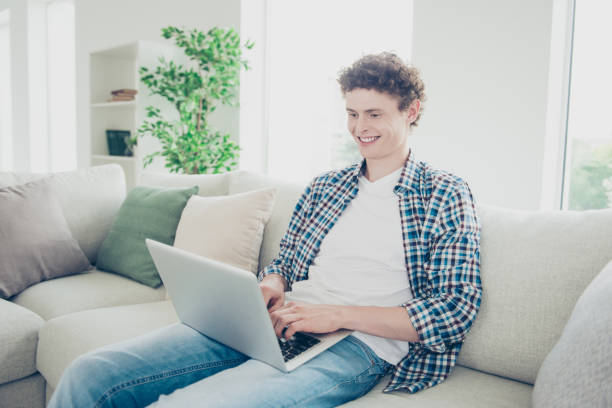 istock Attractive curly-haired smiling young guy student wearing casual 1038908154