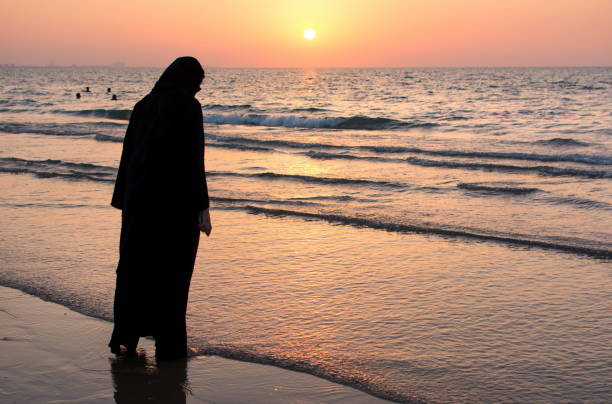 istock Woman in hijab standing on the beach 1038909192