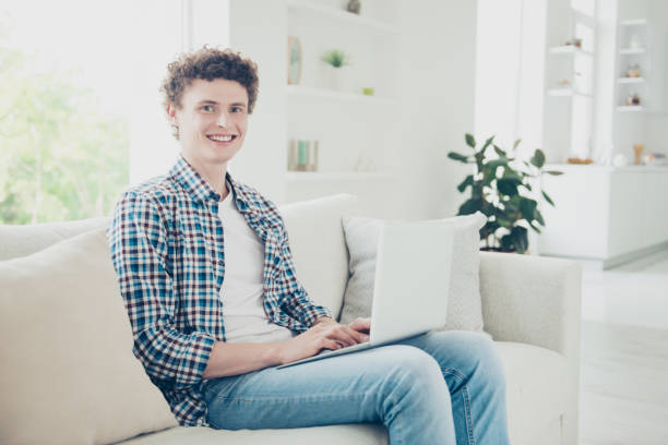 istock Attractive curly-haired smiling young guy student wearing casual 1038917712