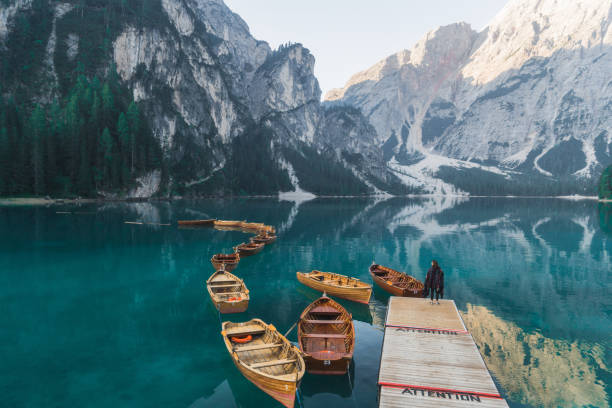 frau, die in der nähe des sees lago di pragser dolomiten - latemar mountain range stock-fotos und bilder