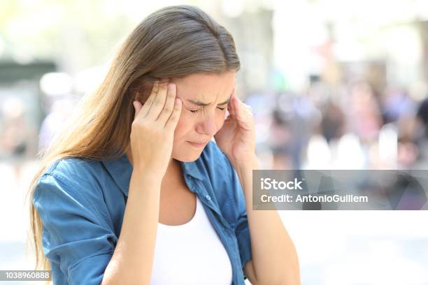 Girl Suffering Migraine In The Street Stock Photo - Download Image Now - Headache, Crowded, Teenager