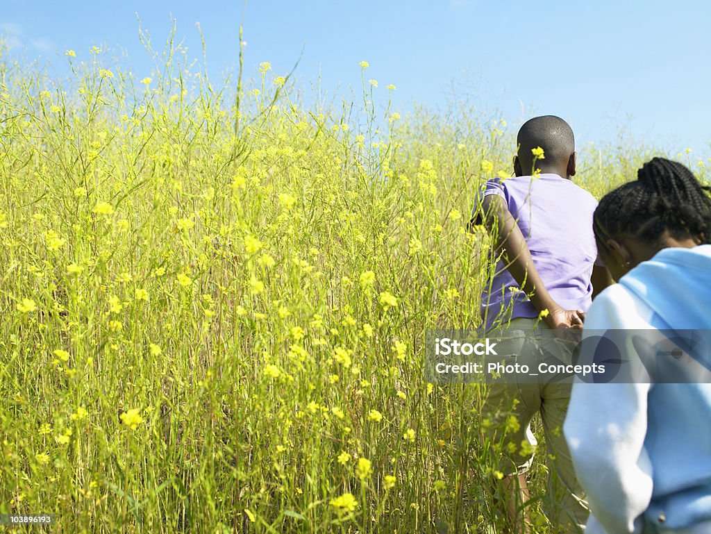Menina e um menino correndo através do campo - Foto de stock de Colina royalty-free